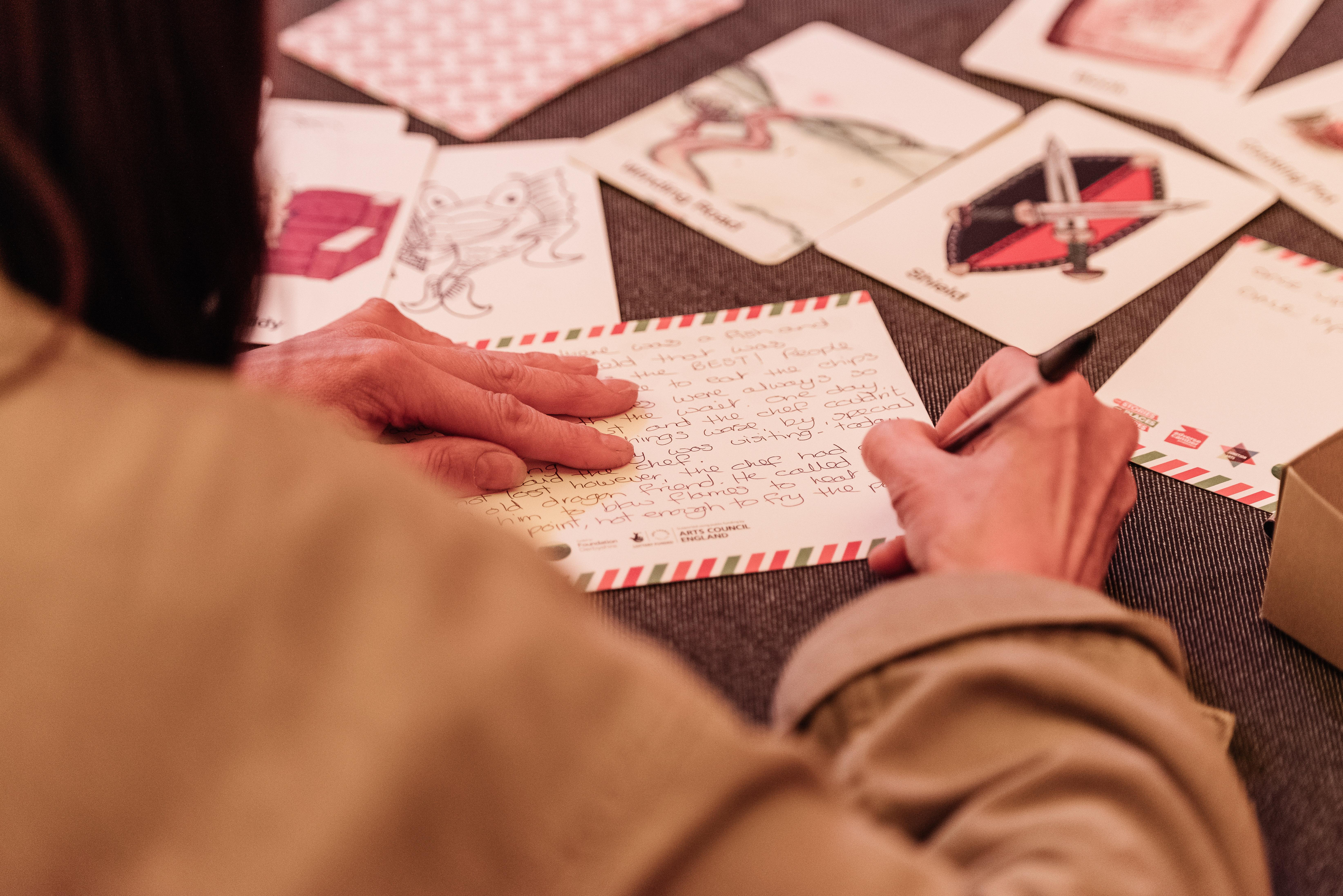 someone writing on a post card