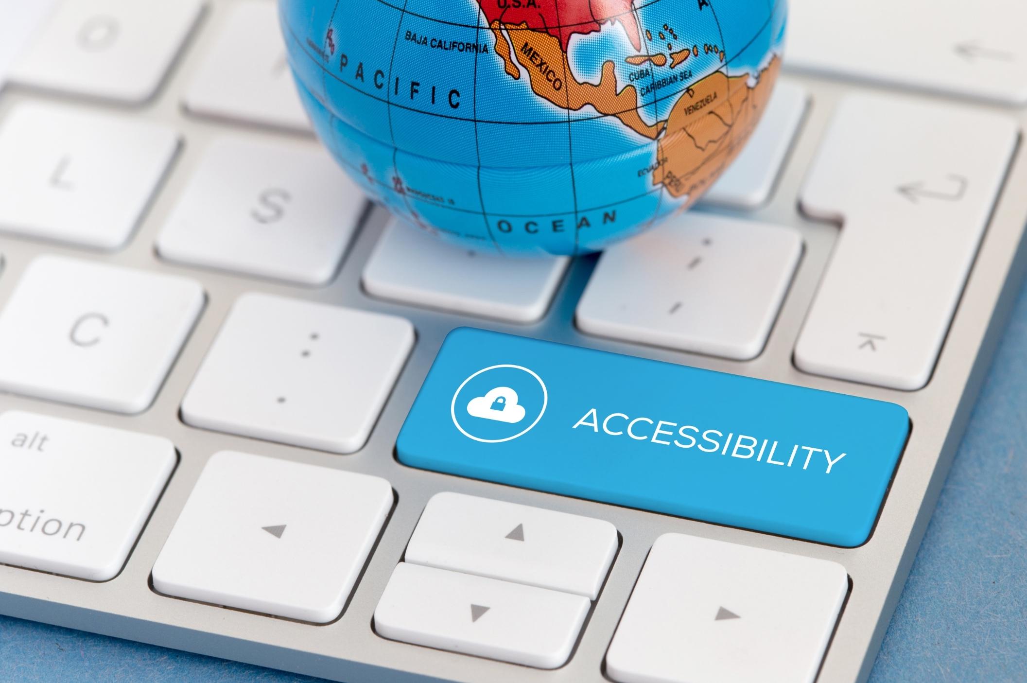 a computer keyboard with a globe and a blue button saying accessibility