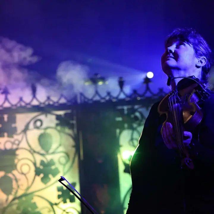 Ann Jones is playing a violin and looking at the sky