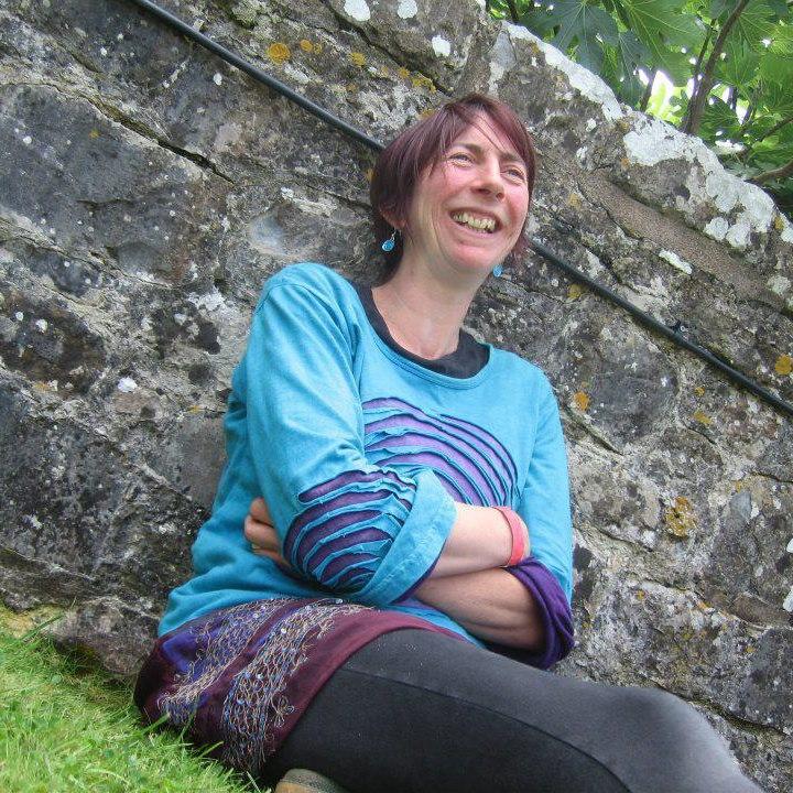 Photo of Rachel sat next to a wall. 