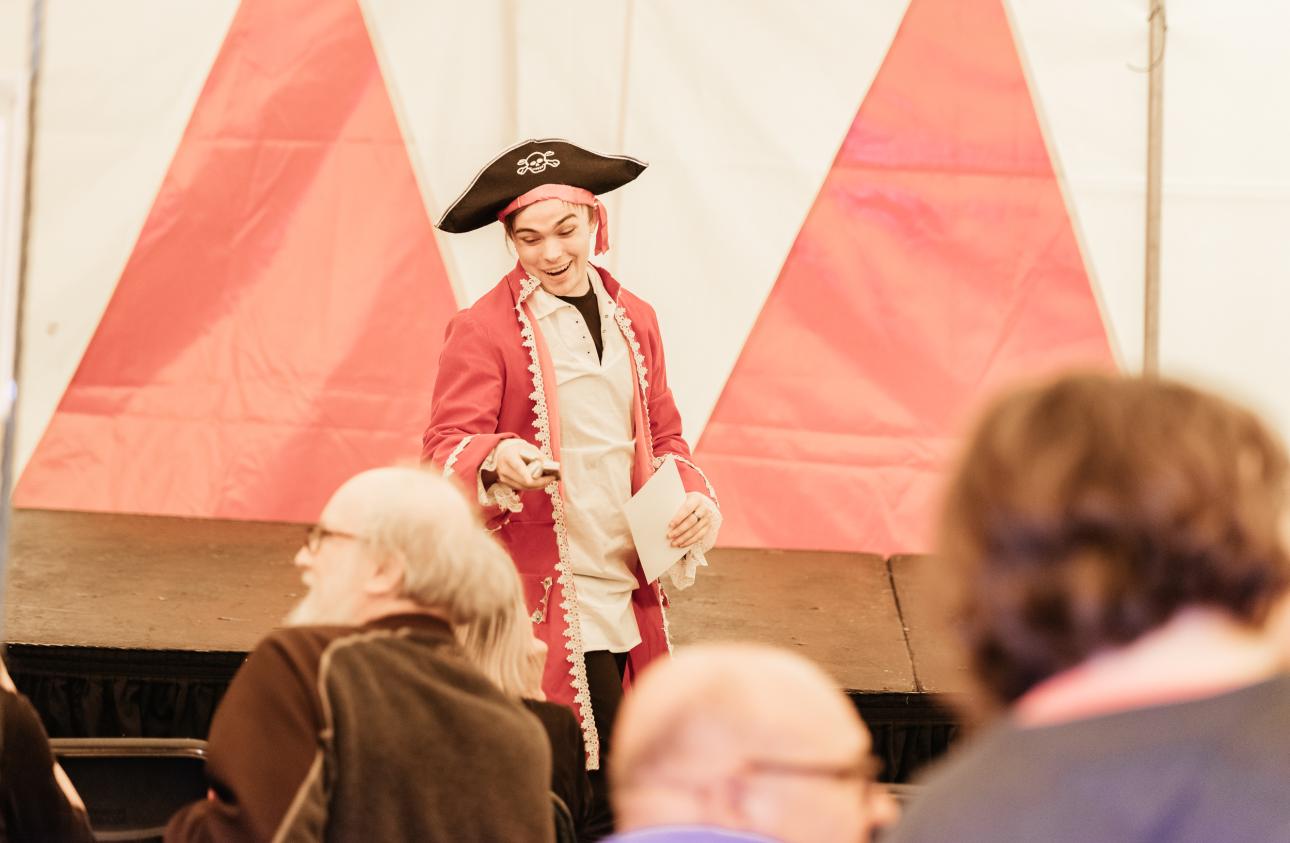 a young man dressed as a pirate smiles at the front of the stage at tapton lock festival