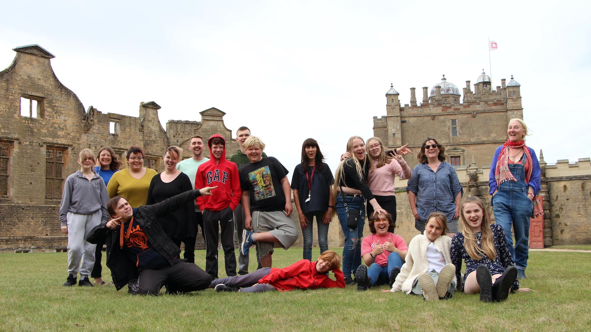 A large group of people pose for a photo outside at Bolsover Castle