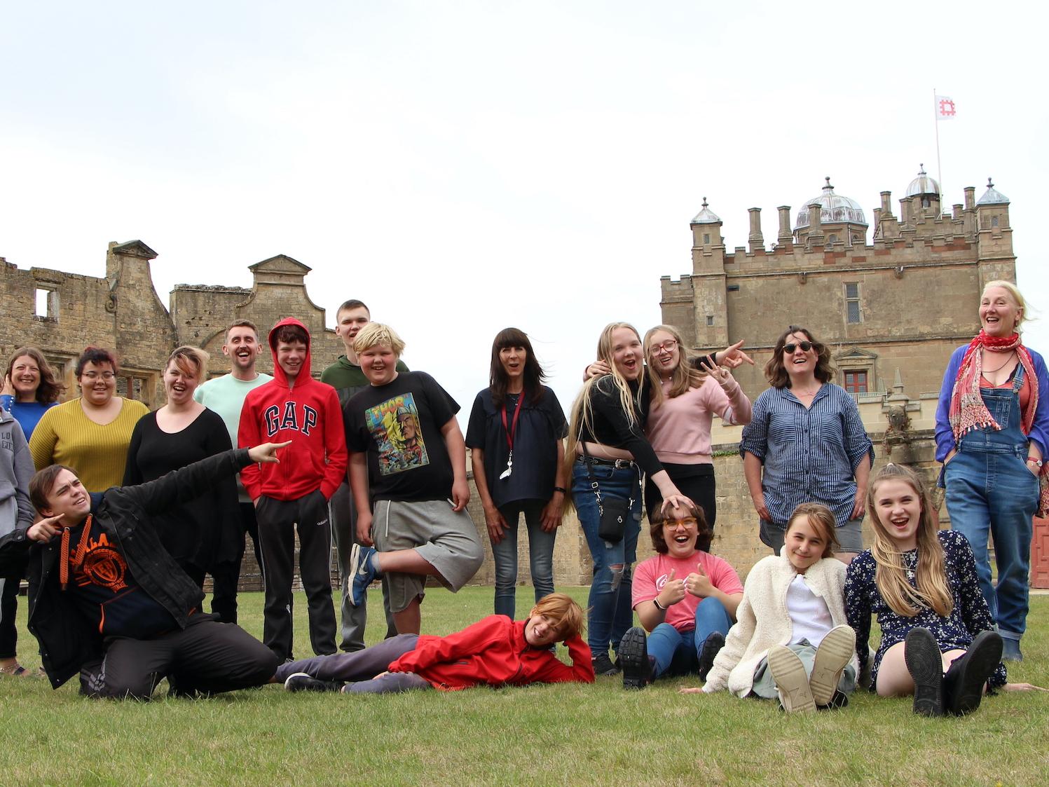 A large group of people pose for a photo outside at Bolsover Castle