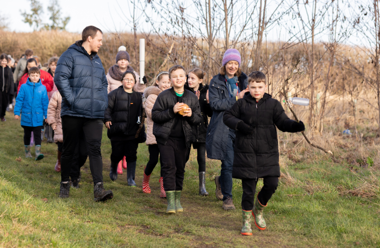 A group of children walking through the woodlands