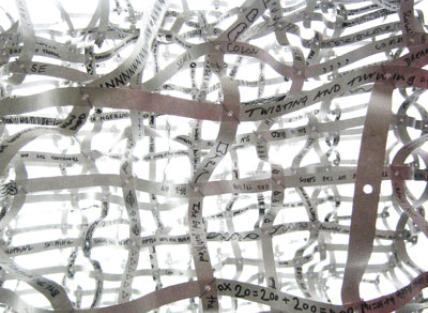 a close up of one of Sophia's pieces of work called Purl, shows lots of strands of paper with numbers and letters written on them
